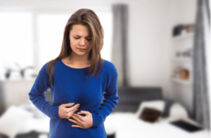 woman suffering stomach ache pressing abdomen